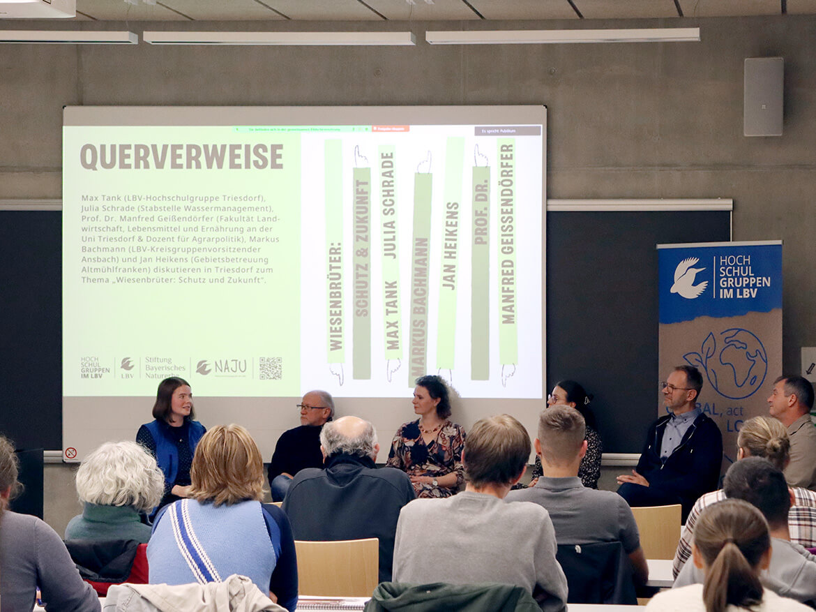 Isabel Rohde und Teilnehmer:innen der Podiumsdiskussion in einem gefüllten Hörsaal in Triesdorf